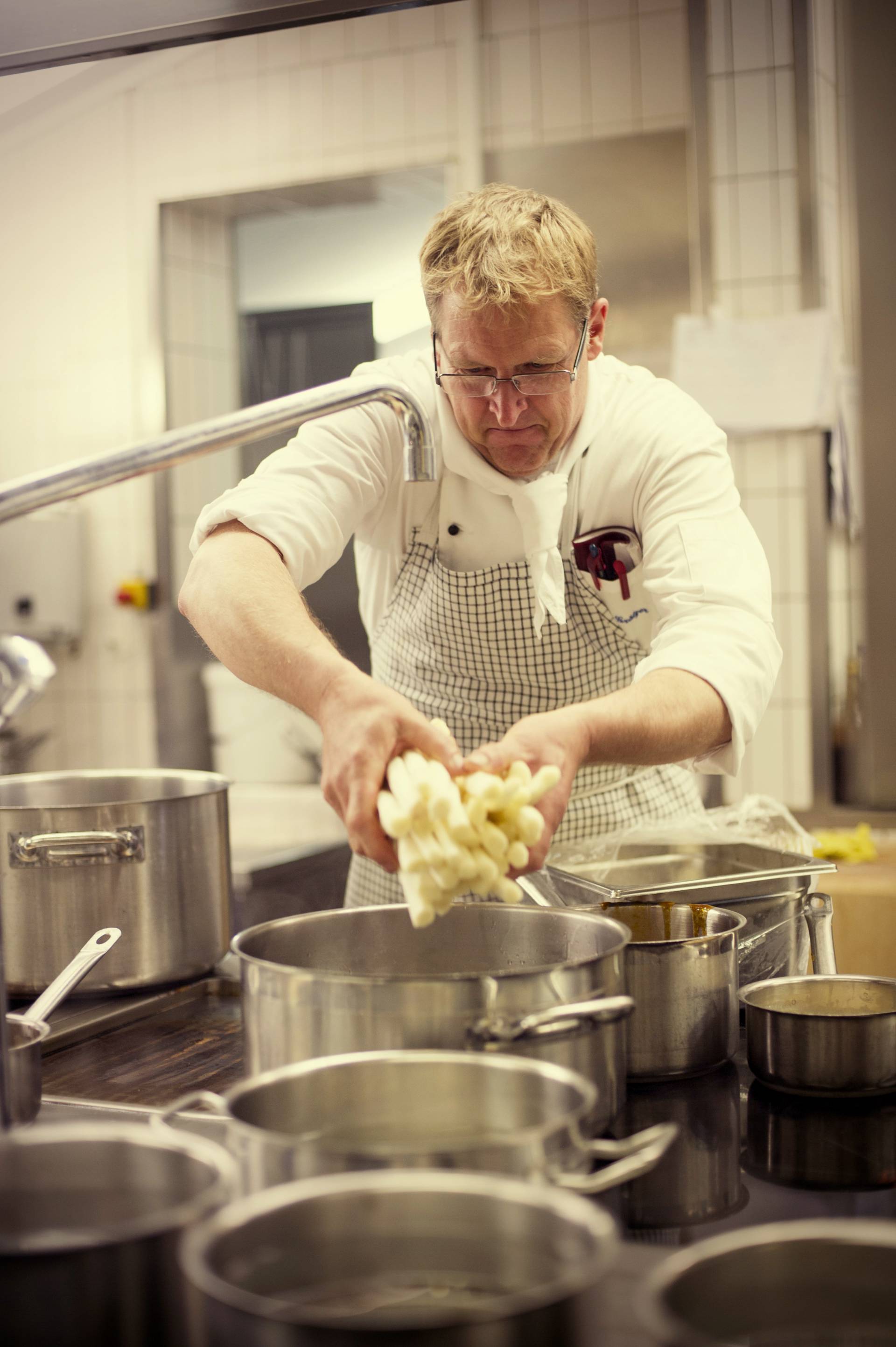 Koch wäscht Spargel