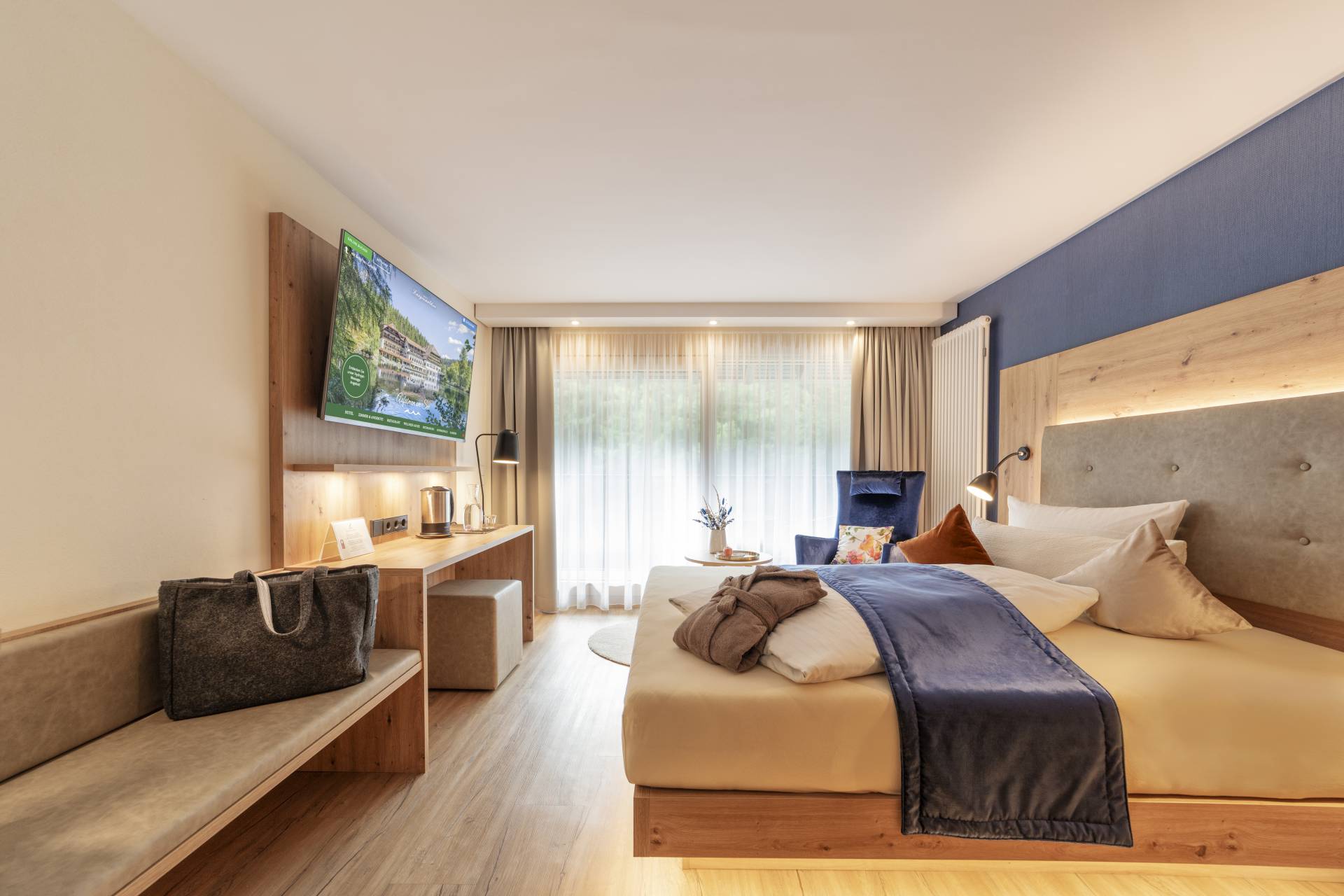 Gemütliches Hotelzimmer mit Doppelbett und Sitzbank