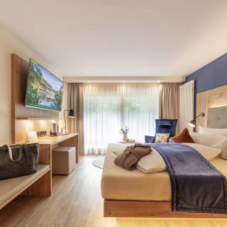 Gemütliches Hotelzimmer mit Doppelbett und Sitzbank