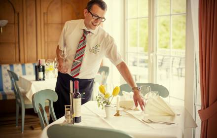 Hotelmitarbeiter deckt den Tisch im Hotel Langenwaldsee ein