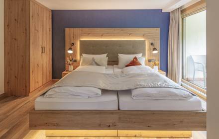 Schlicht beleuchtetes Hoteldoppelbett