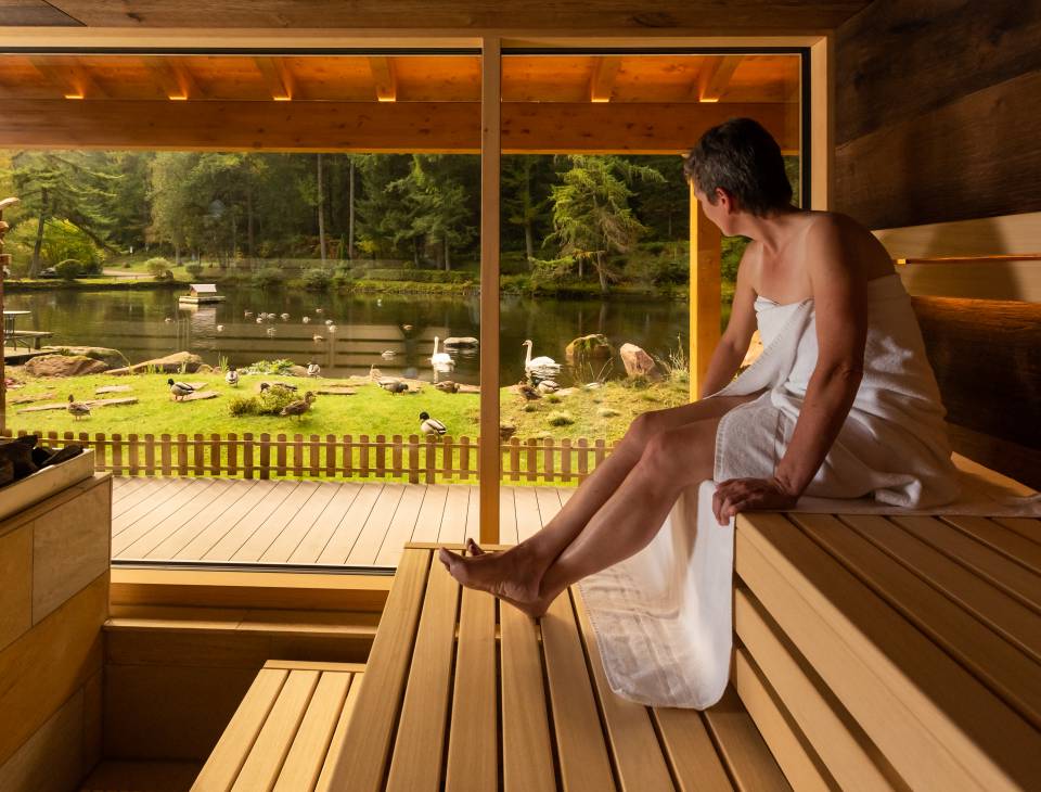 Frau in Panorama Sauna mit Blick auf den See
