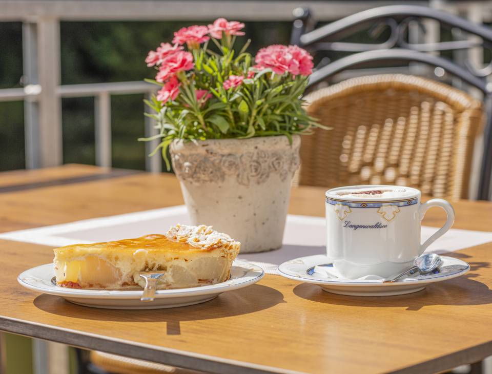 Leckerer Apfel-Käse-Kuchen auf Teller mit einem Cappuccino 
